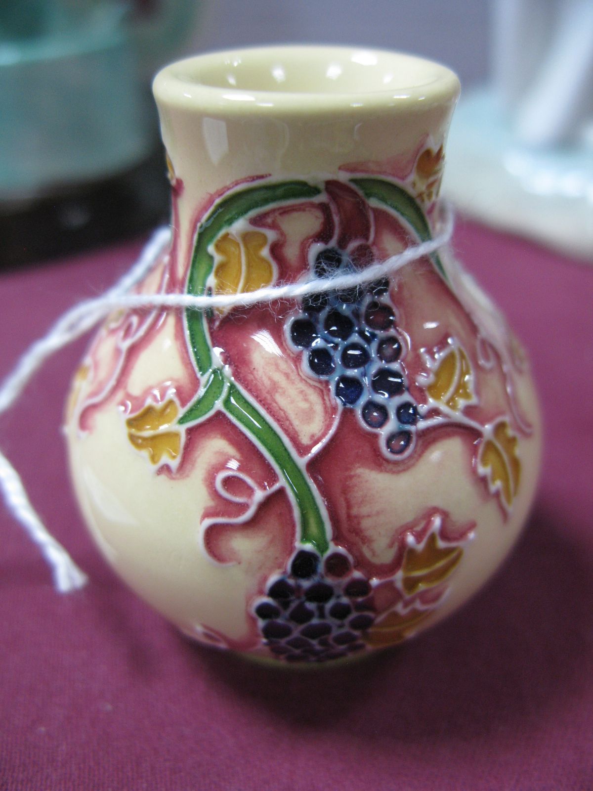 A Moorcroft Pottery Miniature Baluster Vase, decorated with the Corinth Grapes design from the