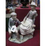 Lladro Figure Group, of a boy and a girl reading a book (Boxed)