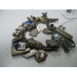 A Curb Link Charm Bracelet, suspending numerous souvenir enamel shield shape pendants and assorted