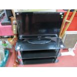 A Samsung 26" Flatscreen TV, with remote control and a black glass TV stand. (2)