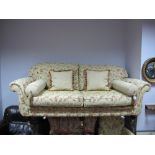 Three Seater Settee, upholstered in a floral fabric, scroll arms on turned and reeded forefront