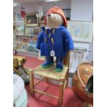 A Mid XX Century Paddington Bear, with blue plastic George boots, and a rush seated chair. (2)