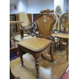 A Victorian Oak Hall Chair, shield back with scrolled outlines, on ball and tapering ring turned