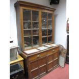 An Early XX Century Oak Bookcase, with a stepped cornice, glazed doors, adjustable shelves, the base