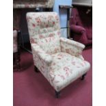 Early XX Century Armchair, upholstered in a floral fabric, on turned legs.