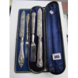 A Decorative Serving Knife and Fork, in original fitted case; together with another pair. (2)