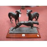 A Pair of Cast Bronzed Figures of Greyhounds, together with a resin figure of a greyhound on stand.