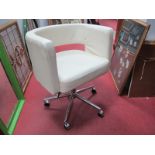 A Modern Swivel Tub Chair, upholstered in cream leatherette, chrome support and castors.