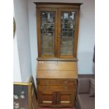 A 1920's Oak Bureau Bookcase, leaded glazed twin doors with interior shelving over fold front and