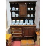 A XX Century Oak Dresser, the upper section with shaped apron piece over open shelving and central