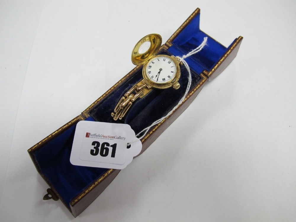 An 18ct Gold Cased Ladies Wristwatch, with half hunter style case, the white enamel dial with