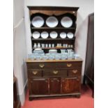 An XVIII Century Oak Dresser, the rack with stepped pediment and shaped cornice above three