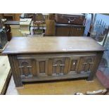 An "Old Charm" Oak Blanket Box, plain hinged top over triple arched carved panels, each with "S"