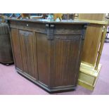 A "Jaycee" Oak Bar, canted ends, with scrolled frieze over linen fold panels.