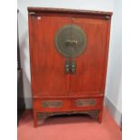 A Chinese Red Lacquer Cabinet, the twin panelled doors with large circular bronzed lock plate