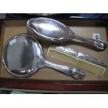 A Hallmarked Silver Backed Hand Mirror, a brush and a comb. (3)
