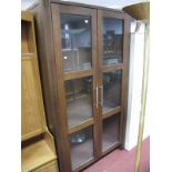 A Modern Display Bookcase, twin three panelled glazed doors and interior shelving.