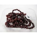 A Graduated Single Strand Cherry Amber Bead Necklace, of forty nine beads, 70cms long; and two