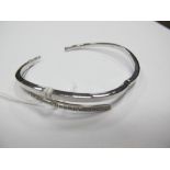 A Modern 9ct White Gold Bangle, inset to the front, hinged to snap clasp.