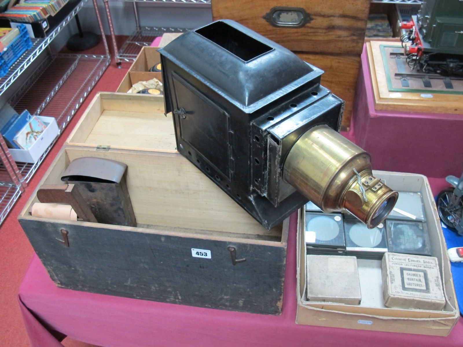 An Early XX Century Magic Lantern, blackened tinplate body with brass adjustable lens, in a pine box