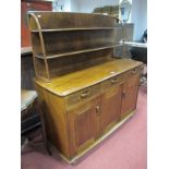 A Stained Wood Sideboard, int the Ercol Style, fitted with two open shelves over three frieze