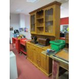 A Pine Kitchen Dresser, with a stepped cornice, open shelves, glazed doors, base with three small