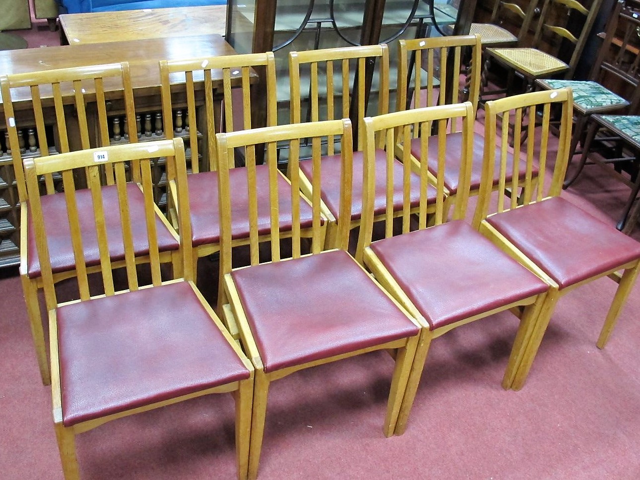 A Set of Eight Mid XX Century Oak Chapel Chairs, with rail backs with red leatherette seats,