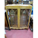 A 1920's Mahogany Bowfronted Display Cabinet, astragal glazed doors with interior glass shelving, on