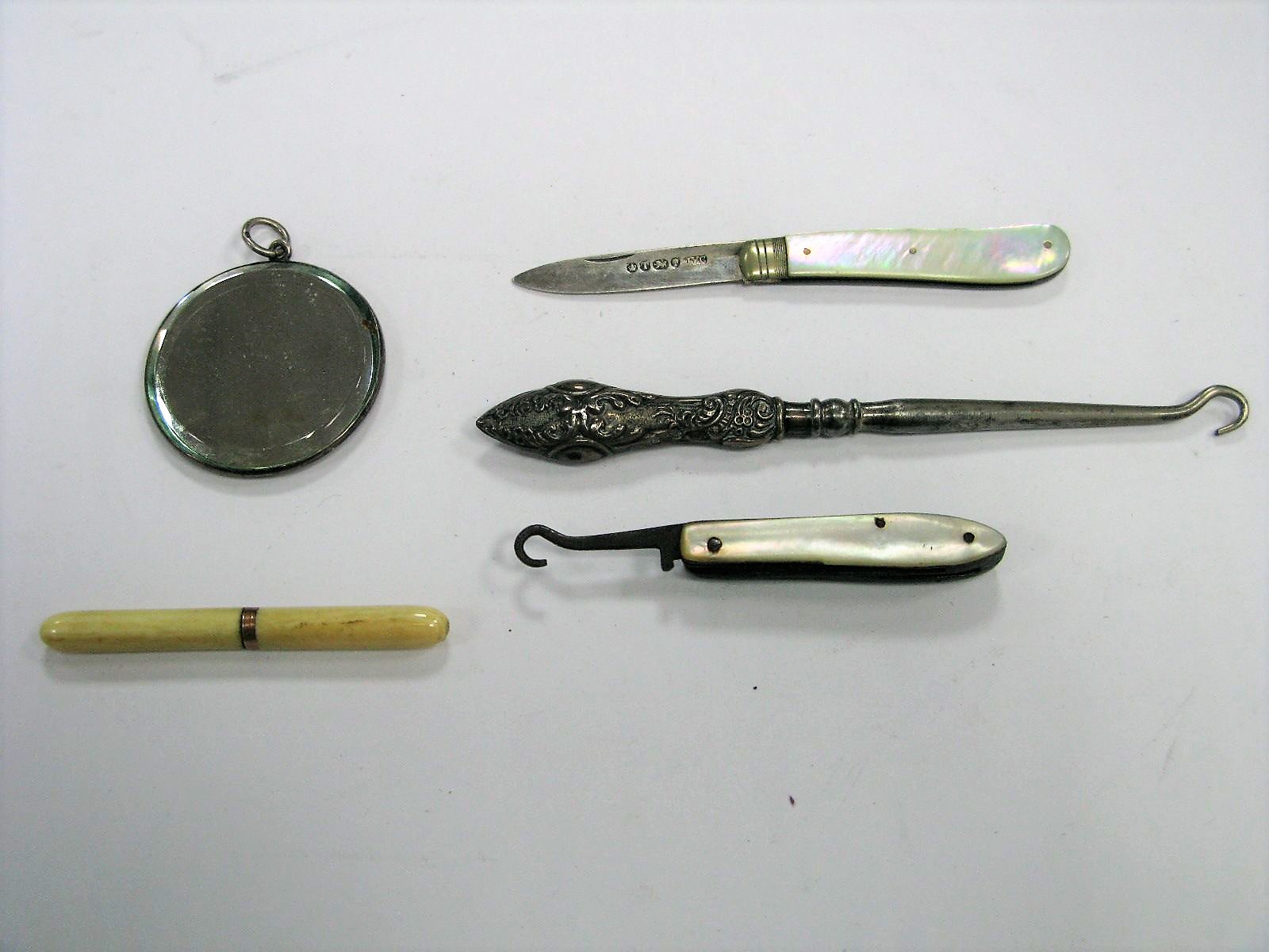 A Victorian Hallmarked Silver and Mother of Pearl Folding Fruit Knife, together with a small mirror,