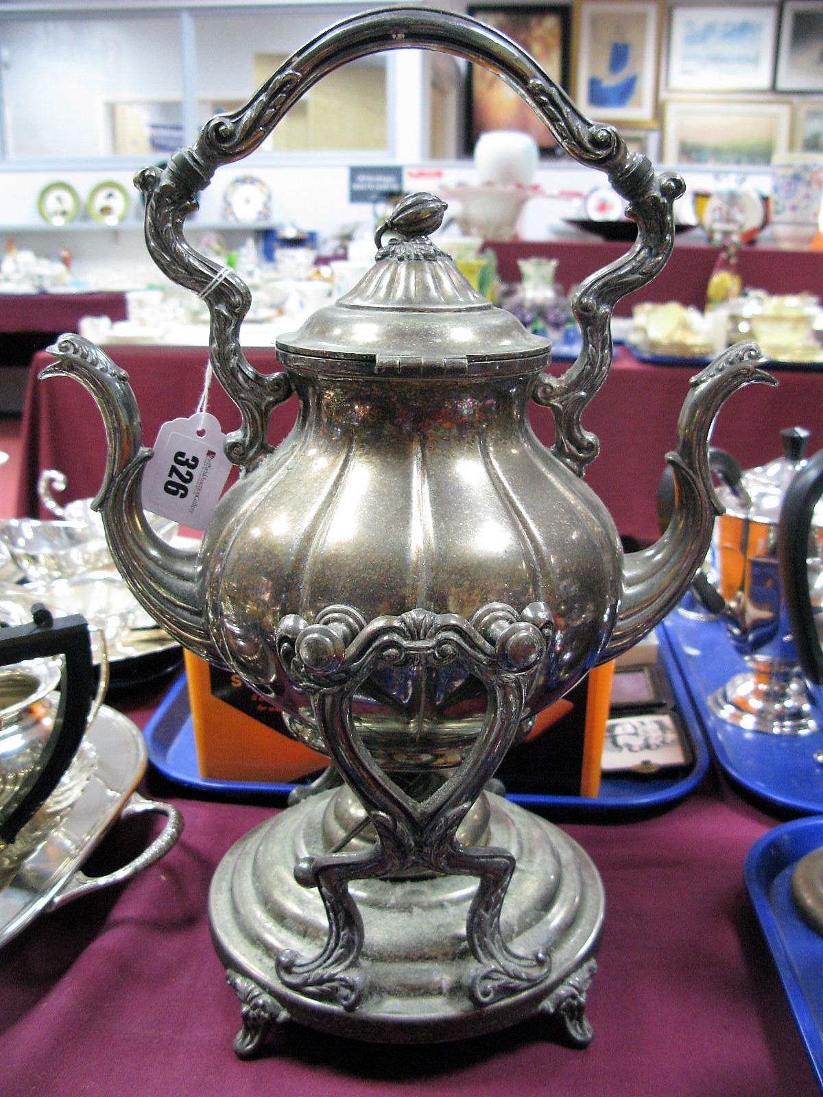 An American Plated Tea Kettle on Burner Stand, with twin spouts and overhead handle.