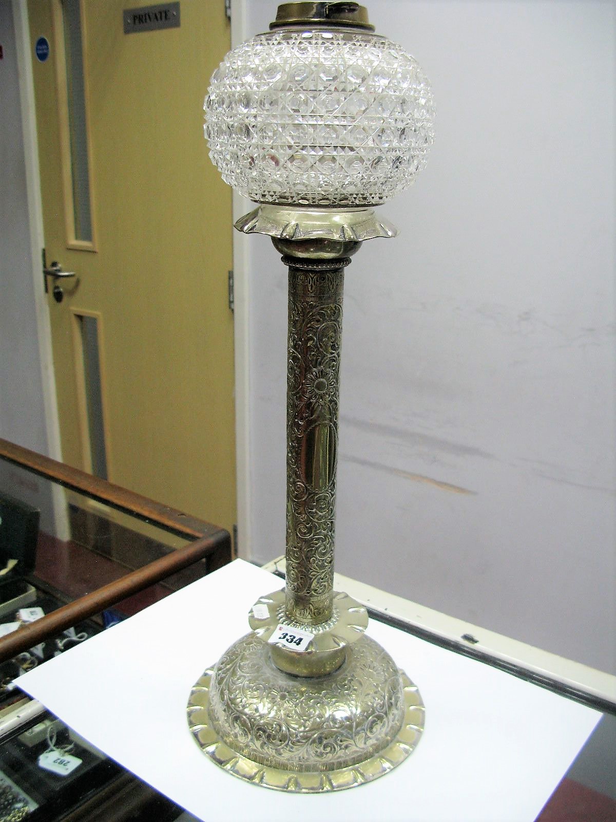 A Hukin & Heath Silver Plated Oil Lamp Base, the circular base and column with scroll leaf