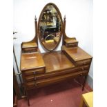 An Edwardian Mahogany Dressing Table, oval bevelled mirror, with finial capped shaped supports and