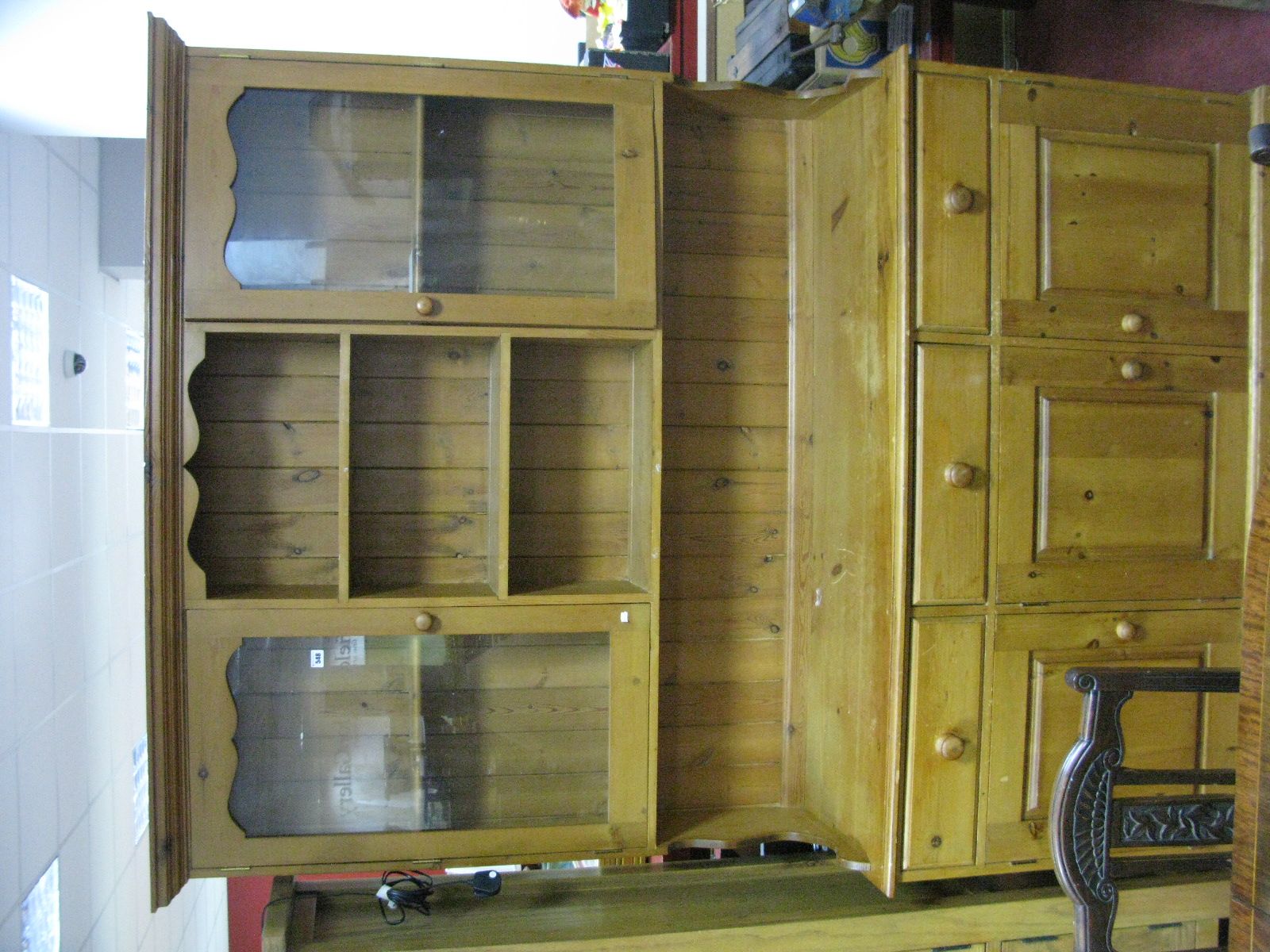 A Pine Kitchen Dresser, with a stepped cornice, open shelves, glazed doors, base with three small