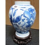 A Dutch Delft Vase of Baluster Form, painted in blue with flowering shrubs, 20cm high, upon a