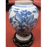 A Dutch Delft Vase of Baluster Form, painted in blue with flowering shrubs, 20cm high, upon a