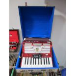 An Argo Piano Accordion, twenty-six key, faux red mother of pearl effect casing.