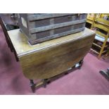 A 1920's Oak Drop Leaf Table, with an oval top, barley twist and block supports, united by
