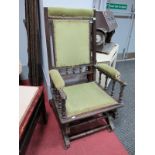 An Early XX Century American Rocking Chair, with spindle supports upholstered in a green velvet.