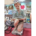 A 1930's Painted Plaster Boy, knelt position holding a rectangular glass water tank, on