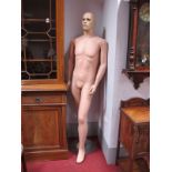 A Modern Mannequin, painted features, no hair, mounted on a stand.