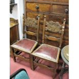 A Pair of XX Century Oak Chairs, shaped and carved top rail, upholstered leather seats, on square