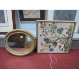 A XIX Century Oval Shaped Gesso Wall Mirror, together with an early XX Century silk panel of