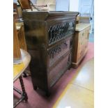 An Early XX Century Oak Three Height Sectional Bookcase, with leaded glazed doors, on paw feet.