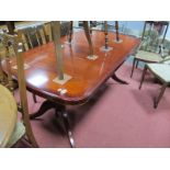 A Mahogany Twin Pedestal Dining Table, with an oval cross banded top, turned pedestals, swept legs.