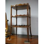 A Reprodux Yew Wood Three Tier Whatnot, with wavy gallery to each shelf, on splayed legs.