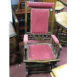 An Edwardian Walnut American Rocker, with spindle supports, upholstered in a red moquette.