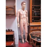 A Modern Male Mannequin, painted moulded hair and facial features, mounted on a stand.