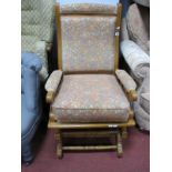 An Early XX Century Oak American Rocking Chair, with an upholstered back and seat, on rockers.