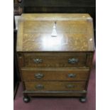 *WITHDRAWN* A 1920's Oak Bureau, with a fall front, three long drawers, on bun feet.