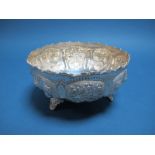 A Decorative Bowl, allover detailed in relief with panels of flowerheads, with wavy rim, raised on